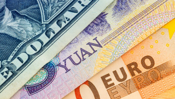 Bankbiljetten van dollar, yuan en euro naast elkaar.