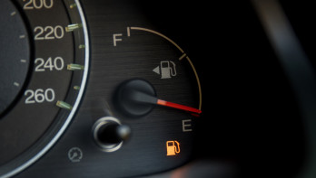 Lege tank auto met rood waarschuwingslampje voor brandstof dat brandt op het dashboard.