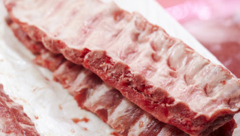 Verse stukken varkensvlees uitgestald op de toonbank van een slager