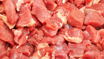 Verse stukken varkensvlees uitgestald op de toonbank van een slager