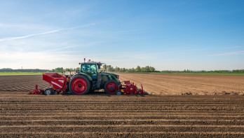 Boer poot aardappelen met pootmachine achter trekker