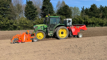 Trekker met pootmachine pot aardappelen op een akker