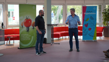 Twee mannen geven staand een presentatie