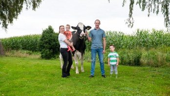 Een gezin poseert met een koe