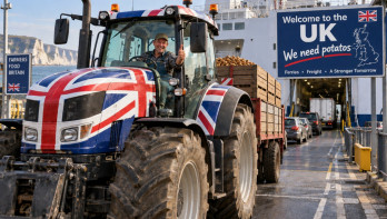 Britse boer rijdt met een met de Union Jack versierde tractor vol aardappelen een veerboot op naar het Verenigd Koninkrijk.