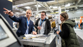 Drie bezoekers van de EuroTier bij een machine