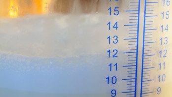 Milliliter-schaalverdeling op een glazen melkopslagtank, close-upfoto