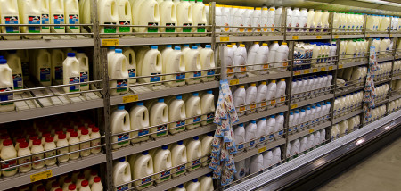 Schappen met melkpakken en flessen in de zuivelsectie van een supermarkt