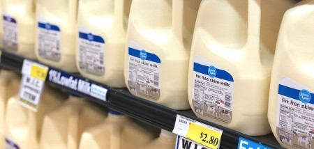 Schappen met melkflessen in de zuivelsectie van een supermarkt