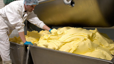 Productie van boter in een zuivelfabriek, verse boter gevormd tijdens industriële verwerking van room