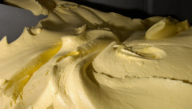 Productie van boter in een zuivelfabriek, verse boter gevormd tijdens industriële verwerking van room