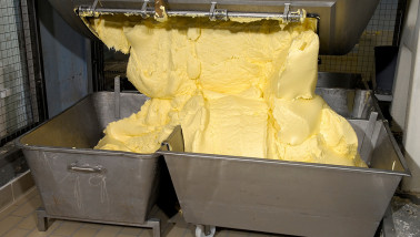 Productie van boter in een zuivelfabriek, verse boter gevormd tijdens industriële verwerking van room