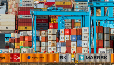 Opgestapelde zeecontainers in een haven- of logistiek gebied.