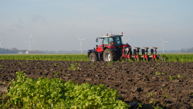 Tractor ploegt het veld om de grond klaar te maken voor het zaaien