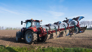 Tractor ploegt het veld om de grond klaar te maken voor het zaaien