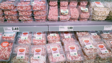 Vleesschap in de supermarkt met verschillende soorten varkensvlees, verpakt en klaar voor verkoop