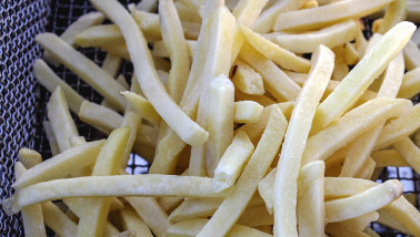 Diepgevroren aardappelfrites klaar om goudbruin gefrituurd te worden