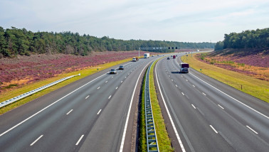 Snelweg A1 door bossen en bloeiende heide op de Hoge Veluwe in Nederland