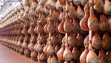 In een hamfabriek hangen rauwe hammen