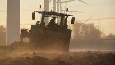 Tractor ploegt het veld om de grond klaar te maken voor het zaaien