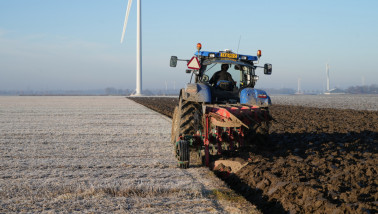 Tractor ploegt het veld om de grond klaar te maken voor het zaaien
