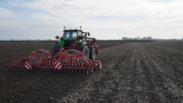Zaaien van tarwe op het akkerland met een tractor en zaaimachine.
