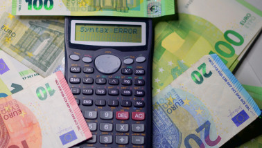 Rekenmachine met eurobankbiljetten ernaast, symbool voor financiën en kostenberekening.