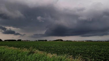Donkere wolken boven een akkerbouwperceel, wijzend op naderend onweer.