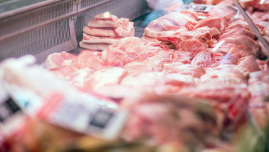 Verse stukken varkensvlees uitgestald op de toonbank van een slager