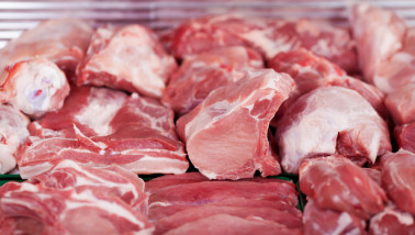 Verse stukken varkensvlees uitgestald op de toonbank van een slager