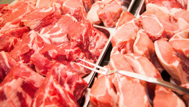 Verse stukken varkensvlees uitgestald op de toonbank van een slager