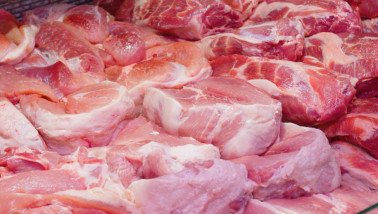 Verse stukken varkensvlees uitgestald op de toonbank van een slager