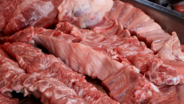 Verse stukken varkensvlees uitgestald op de toonbank van een slager