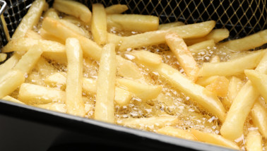 Verse aardappelfrites worden goudbruin gefrituurd in hete olie
