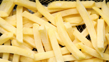 Diepgevroren aardappelfrites klaar om goudbruin gefrituurd te worden