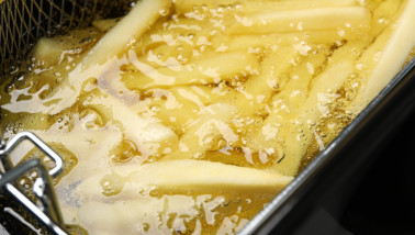 Verse aardappelfrites worden goudbruin gefrituurd in hete olie