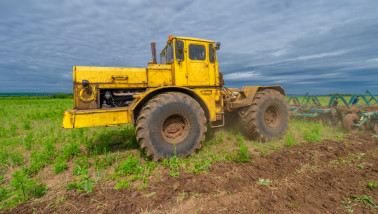 Een tractor die het land ploegt tijdens grondbewerking.