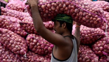 Indian labourer carrying a bag of onions at a wholesale market in Guwahati
