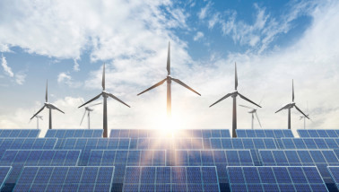 Zonnepanelen en windturbines onder een blauwe lucht