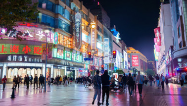 Nanjing Road in Shanghai bruist van mensen onder kleurrijke neonlichten