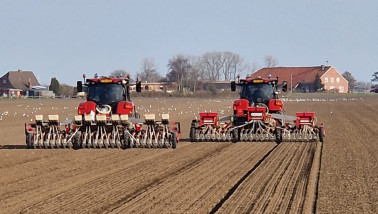 Twee trekkers zaaien uien op akkerbouwperceel