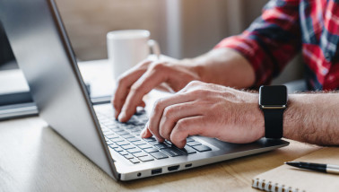 Man werkend achter een laptop, werksituatie