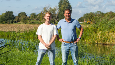 Twee mannen poseren bij het water