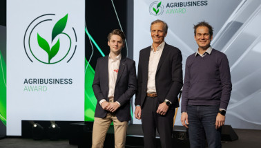 3 mannen poseren lachend op een event