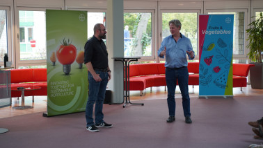 Twee mannen geven staand een presentatie