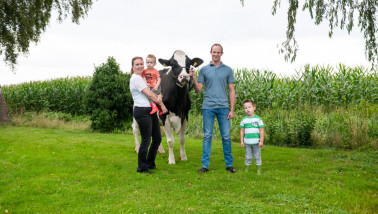 Een gezin poseert met een koe
