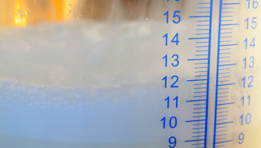 Milliliter-schaalverdeling op een glazen melkopslagtank, close-upfoto