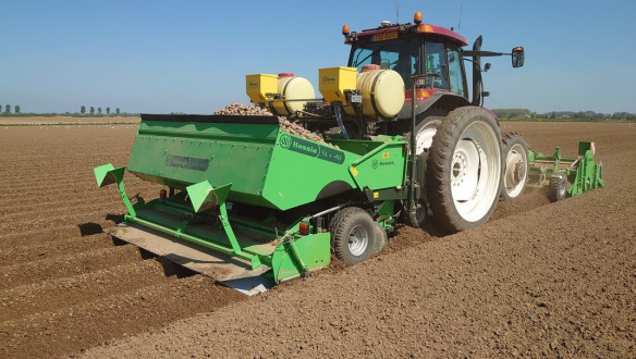 Aardappelen poten op het land met landbouwmachines.