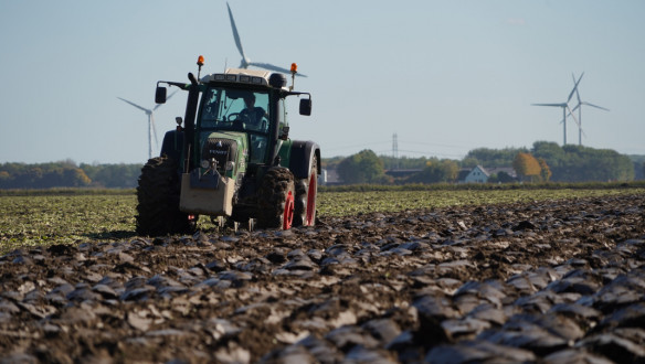 Tractor ploegt het veld om de grond klaar te maken voor het zaaien