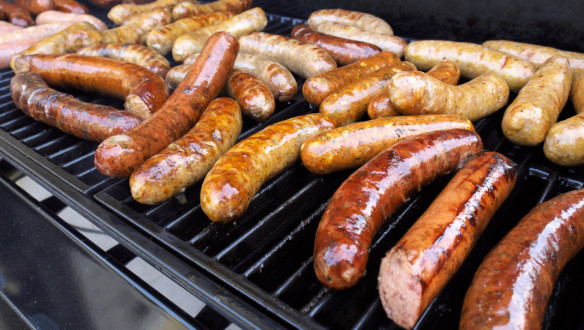 Worstjes op de barbecue die worden gegrild.